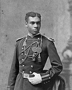 Black and white photo of an African American Soldier posed in his West Point uniform. 