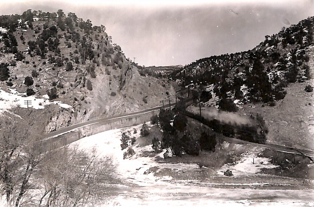 road and train running through a valley