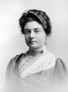 Anita Newcomb McGee in a dress with a medical pin cross on her collar