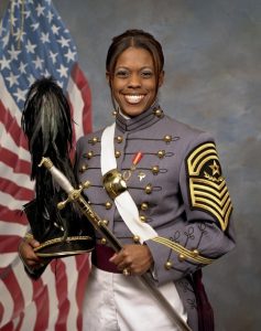 Emily Perez in her West Point uniform holding her cap and saber.