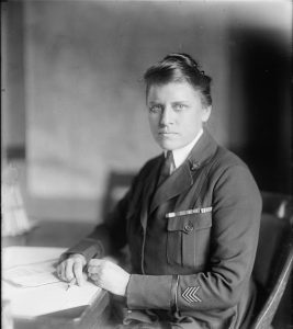 Julia Stimson in uniform, seated at a table. 