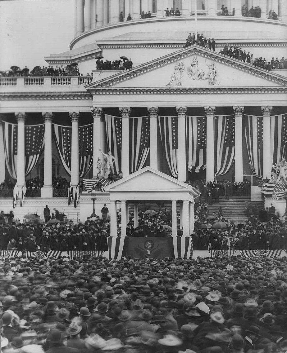 McKinley making speech to crowd in foreground; U.S. Capitol in background.