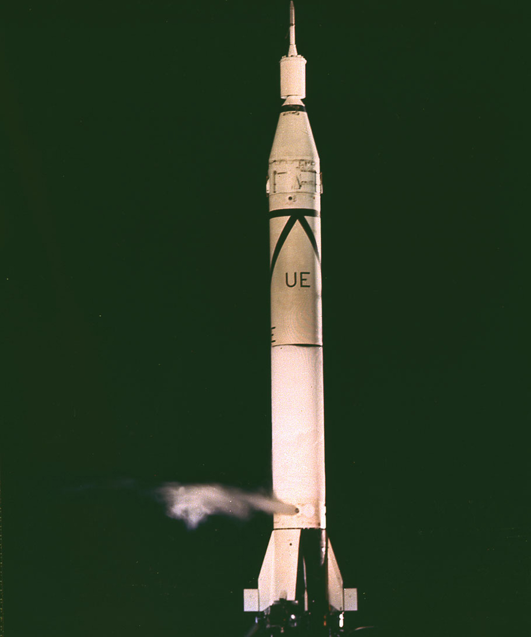 A rocket sits against a dark sky. 