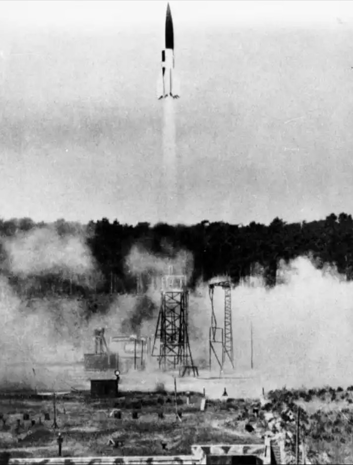 A rocket blasts upward and covers the ground with smoke. 