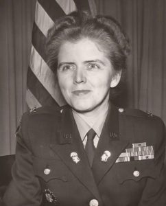 Mary Hallaran in uniform, head and shoulders with American flag behind her. 