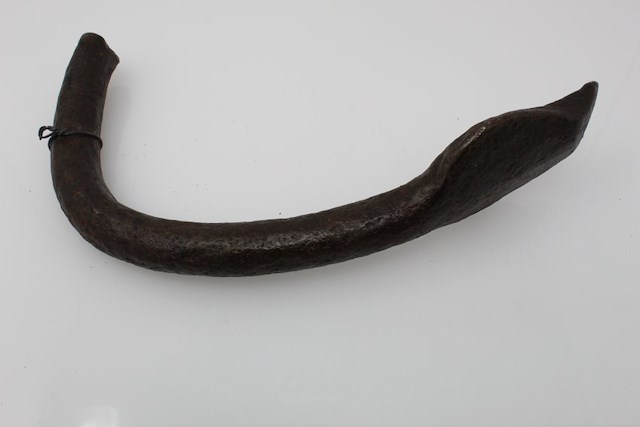 Fragment of an anchor including the fluke and part of the curved arm of the anchor. The end is broken off before the crown where it would join to the shank and other arm of the anchor. Object ID MC11. Courtesy of The Fort Ticonderoga Museum Collection.