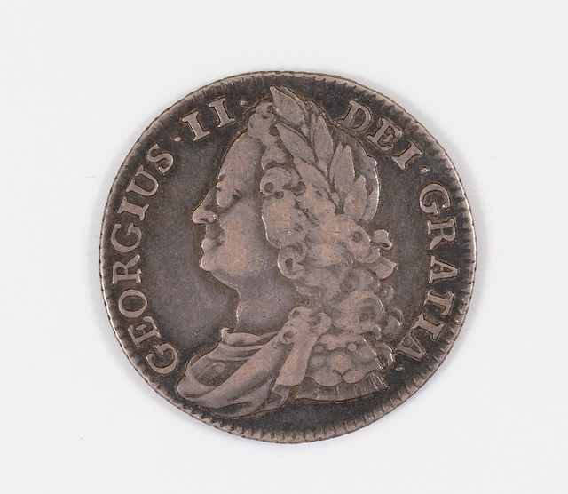 One shilling dated 1747. A shilling was worth 12 pence (or 12 pennies).The face of the coin features a bust of King George II of Great Britain (1683-1760).Object ID 2022.2.457. Courtesy of the Fort Ticonderoga Museum Collection.